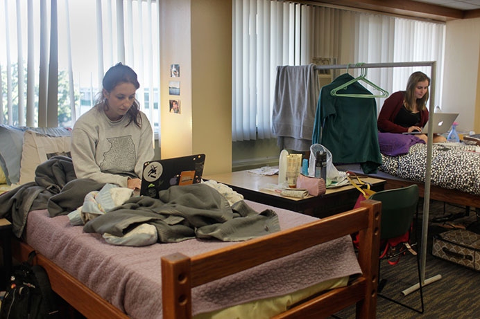 UI junior Olivia Loechner and freshman Sydney McMurray sit in a UI dorm lounge they share with three other women on Monday, Aug. 24, 2015. An overflow of students stay in residence-hall lounges converted into housing spaces until permanent accommodations can be made. (The Daily Iowan/Carly Matthew)