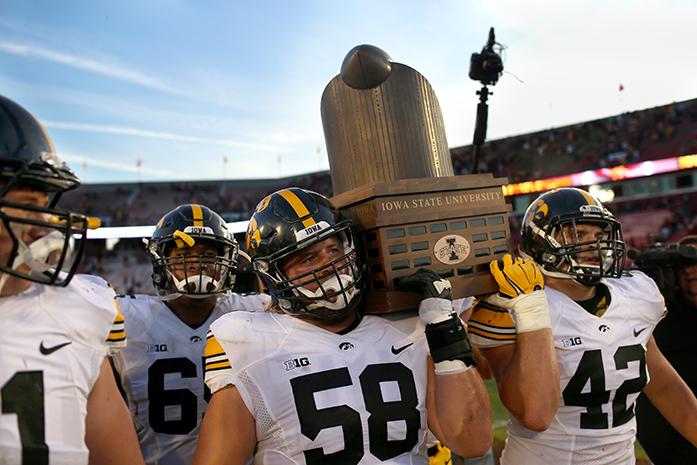 Iowa offensive lineman Eric Simmons and fullback Marcon Plewa carry the Cy-Hawk trophy off the field after defeating Iowa State at Jack Trice Stadium on Saturday, Sep. 12, 2015 in Ames, Iowa. The Hawkeyes defeated the Cyclones, 31-17. (The Daily Iowan/Joshua Housing)