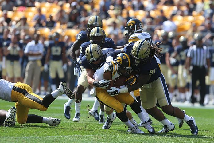 Iowa running back Jordan Canzeri gets tackled by Pitt defenders during the game at Heinz Field in Pittsburgh, Pennsylvania on Saturday, Sept. 20, 2014. Canzeri ran had eight carries for 23-yards on the game. Iowa defeated Pitt, 24-20. (The Daily Iowan/Tessa Hursh)