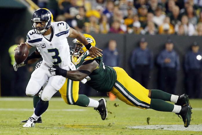 Green Bay Packers Mike Daniels tries to stop Seattle Seahawks Russell Wilson (3) during the first half of an NFL football game Sunday, Sept. 20, 2015, in Green Bay, Wis. (AP Photo/Mike Roemer)