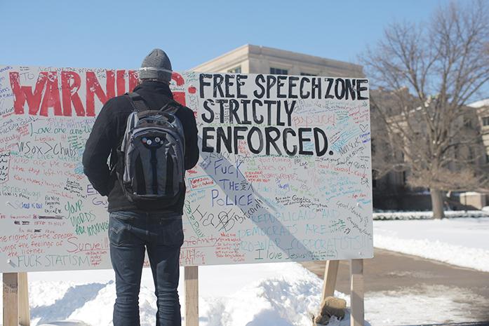 FILE - UI senior Spencer Smith writes on a board for the Freedom of Speech protest put on by Young Americans for Liberty group on the Pentacrest on Thursday, Feb. 26, 2015. 
