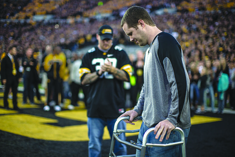 Brett Greenwood walks towards the field at Kinnick Stadium on Saturday, Sept. 19, 2015. Greenwood was named an honorary team captain on Saturday. Greenwood suffered from a heart condition and when he recovered it left him with neurological issues. (The Daily Iowan/Sergio Flores)
