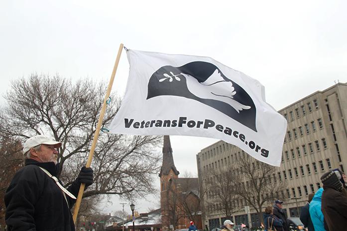 FILE - A member of Veterans for Peace local Chapter #161 holds a sign for the VFP organization at the Pentacrest on Tuesday, Nov. 11, 2014. (The Daily Iowan/Courtney Hawkins, file)