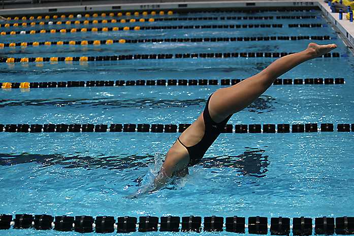 Iowa swimmer jumps into the pool during media day at the CRWC on Wednesday, Oct. 1, 2014. The swimming team opens there season at home this Friday hosting Michigan and Nebraska. (The Daily Iowan/Margaret Kispert)