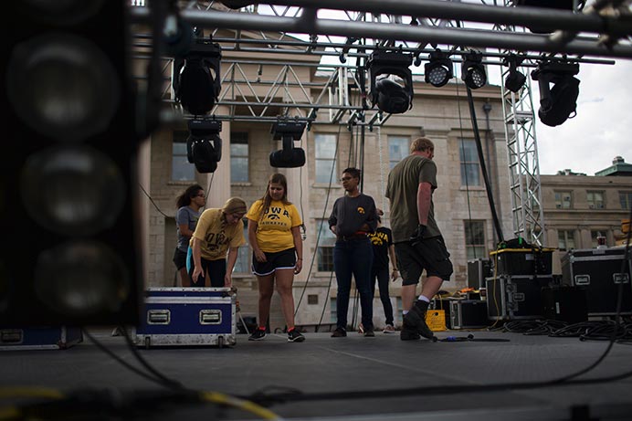 Students involved with Scope begin to set up stage equipment on the Pentacrest stage on Thursday in preparation for an outdoor concert that will take place today after the parade. CHVRCHES, a Scottish electronic band, performed a free show for Homecoming.