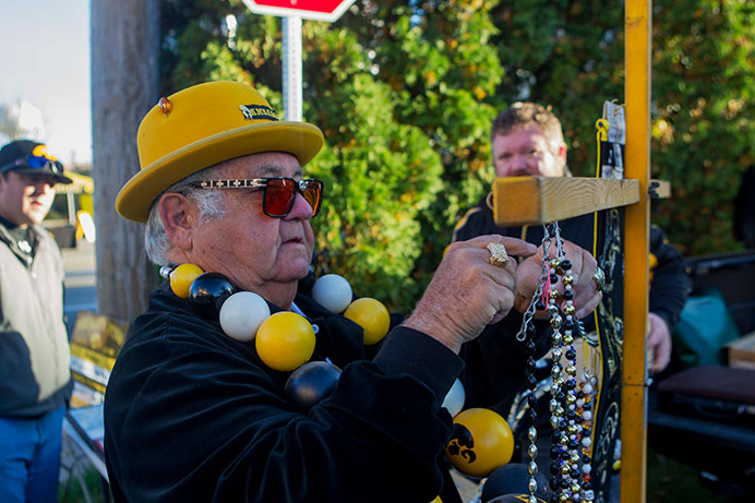 The Hawkeye Ambassador hangs his beads on a cross near Melrose Ave. on Saturday, Oct. 10, 2015. Ryan has been selling souvenirs for about 30 years. (The Daily Iowan/Peter Kim)