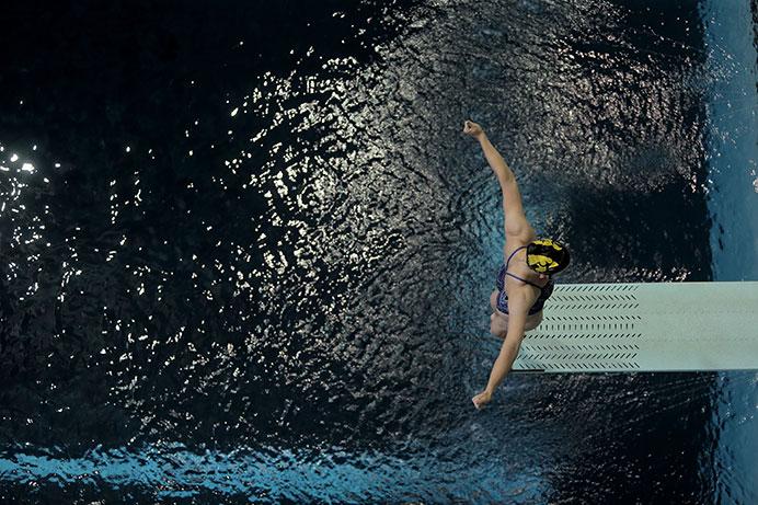 A female diver prepares to jump at the CRWC at the University of Iowa on Tuesday. Two members of the Diving team, Calli Head and Lydia Lehnert, will compete in Omaha in June of 2016 for Olympic spots. (The Daily Iowan/Karley Finkel)