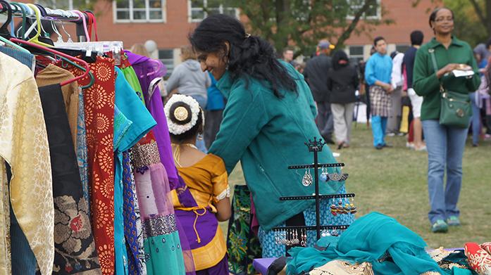 A mother and her child, one of the dancers of the Nooper Dance Troupe, looking at the homemade Indian clothing and jewelry at a stand at the Cultural Diversity Fair in Hubbard Park on Sunday, October 4, 2015. (The Daily Iowan/Rebecca Bright)