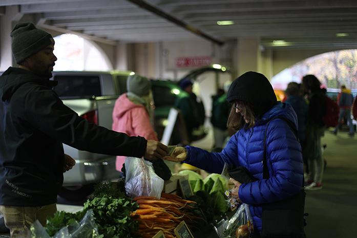 A woman purchases her groceries from the Iowa City Farmers Market on Oct, 28. The Market ended Oct 31, and the Winter market will start on Nov, 8. (The Daily Iowan/Glenn Sonnie Wooden)