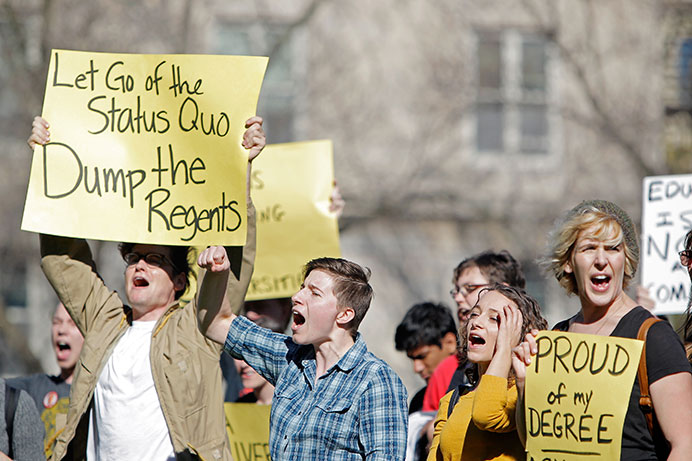 UI students and faculty gather in front of Jessup Hall on Monday. A new university organization, Iowans Defending Our Universities, protested the Board of Regents and called on the regents to resign. Monday was the first official day for new UI President Bruce Harreld. (The Daily Iowan/Courtney Hawkins)