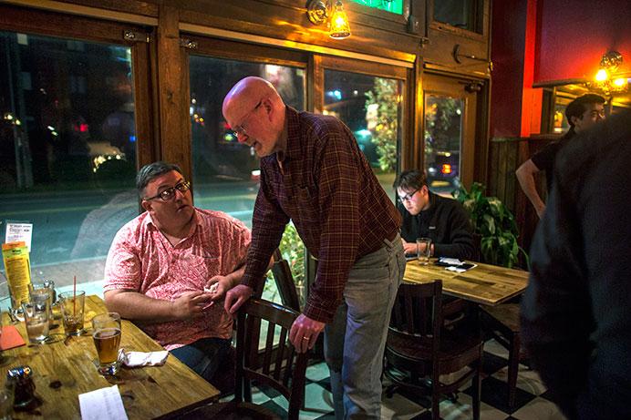 Rod Sullivan(left), a member of the Iowa City Board of Supervisors speaks with Jim Throgmorton (right) inside Sanctuary Pub on Tuesday. Throgmorton is expected to be named Iowa City’s new mayor after Tuesday’s election. (The Daily Iowan/Sergio Flores)