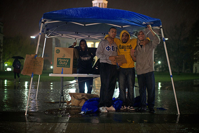 Phi Beta Sigma Fraternity camps out in the rain for homeless relief on Thursday. Participants stressed that there is a great need for feminine body care product donations. (The Daily Iowan/Jordan Gale)