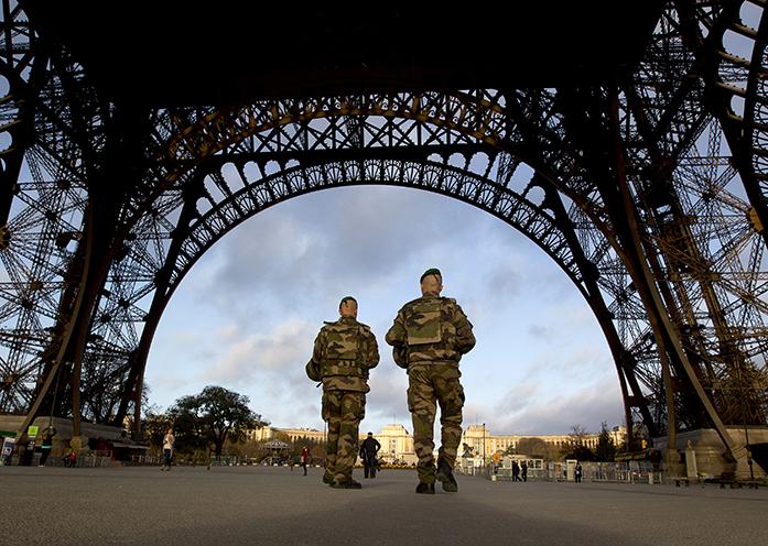 FILE - In this Sunday, Nov. 15, 2015, file photo, French soldiers patrol at the Eiffel Tower which remained closed on the first of three days of national mourning in Paris. Coming soon after the Islamic State group claimed the downing of the Russian plane in Egypt and deadly suicide bombings in Lebanon and Turkey, the Paris attacks appear to signal a fundamental shift in strategy toward a more global approach that experts suggest is likely to intensify. (AP Photo/Peter Dejong, File)