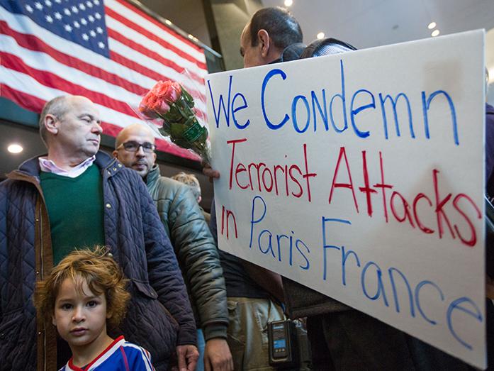 Nasser Jamali holds a sign during a rally of solidarity at the Consulate General of France, Sunday, Nov. 15, 2015, in Atlanta. Multiple attacks across Paris on Friday night have left scores dead and hundreds injured.   (AP Photo/Branden Camp)