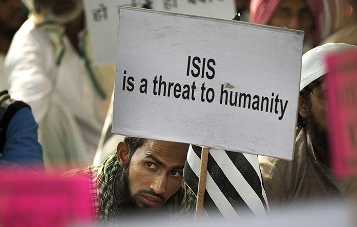 An Indian Muslim man holds a banner during a protest against ISIS, an Islamic State group, and Fridays Paris attacks, in New Delhi, India, Wednesday, Nov. 18, 2015. Multiple attacks across Paris on Friday night have left more than one hundred dead and many more injured. (AP Photo/Manish Swarup)