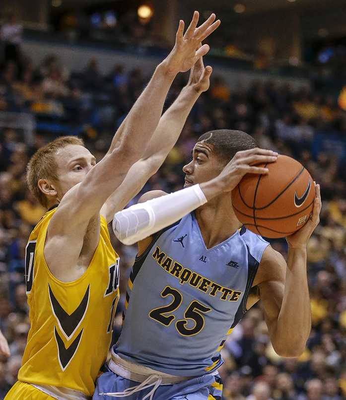 Marquettes Haanif Cheatham looks to pass the ball as Iowas Mike Gesell defends during the first half of an NCAA college basketball game Thursday, Nov. 19, 2015, in Milwaukee. (AP Photo/Tom Lynn)