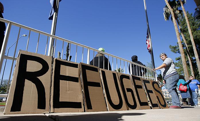 A sign welcoming Syrian refugees is placed at the entrance to the office of the Arizona governor during a rally at the Arizona Capitol Tuesday, Nov. 17, 2015, in Phoenix.   Arizona Gov. Doug Ducey has joined a growing number of governors calling for an immediate halt to the placement of any new refugees in the wake of terrorist attacks in Paris.  The U.S. State Department says Arizona has received 153 Syrian refugees so far this year. (AP Photo/Ross D. Franklin)