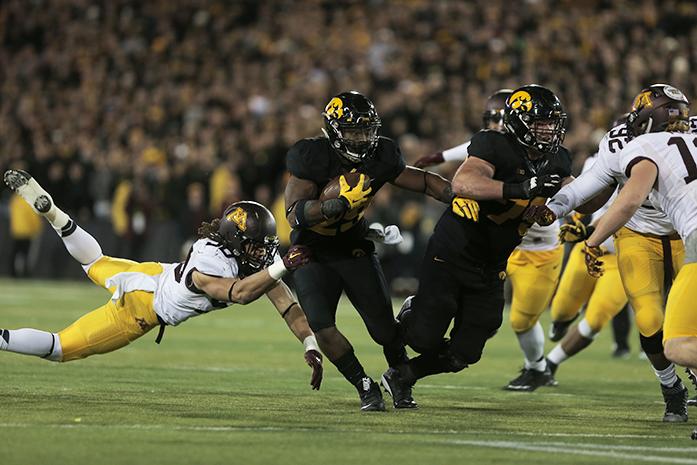Iowa+running+back+LeShun+Daniels%2C+Jr.+runs+with+the+ball+during+the+Iowa-Minnesota+game+at+Kinnick+on+Saturday%2C+Nov.+14%2C+2013.+The+Hawkeyes+defeated+the+Golden+Gophers%2C+40-35+to+stay+perfect+on+the+season.+%28The+Daily+Iowan%2FMargaret+Kispert%29