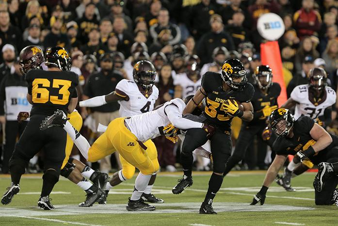Iowa running back Jordan Canzeri tries to avoid a tackle during the Iowa-Minnesota game at Kinnick on Saturday, Nov. 14, 2013. The Hawkeyes defeated the Golden Gophers, 40-35 to stay perfect on the season. (The Daily Iowan/Margaret Kispert)