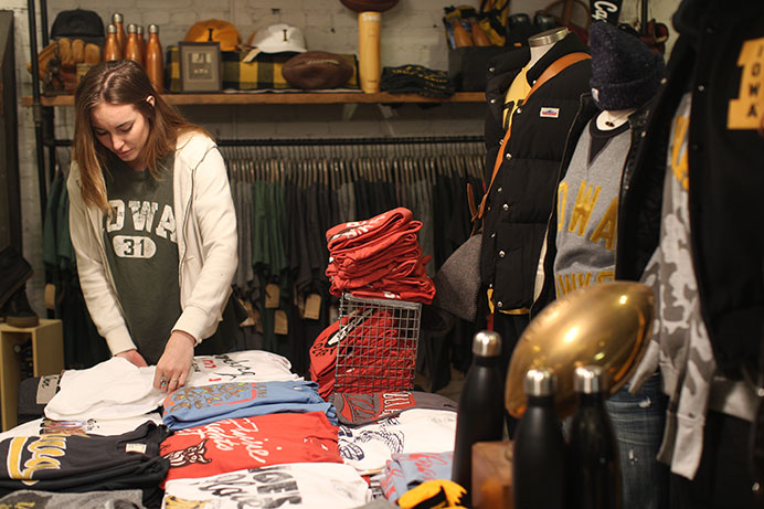Employee at Tailgate Samantha Peterson organizes clothes in the Tailgate clothing store near the intersection of Clinton St. and Washington St. on Tuesday, Dec. 8, 2015. Tailgate first opened June of 2014. (The Daily Iowan/Joshua Housing)