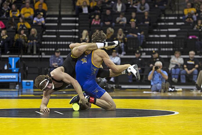 Iowa wrestler Alex Meyer gets thrown over the shoulder of a South Dakota State wrestler. (Daily Iowan/Karley Finkel)
