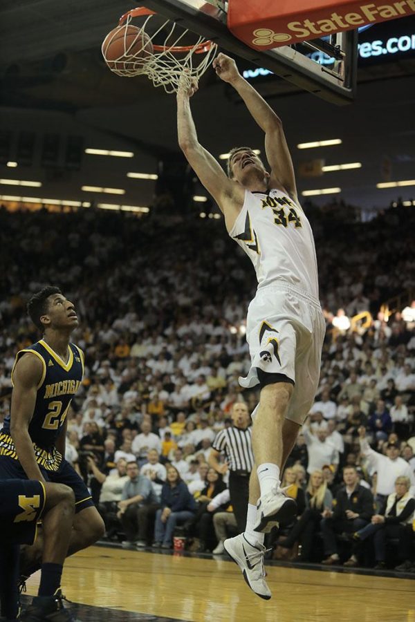 Iowa center Adam Woodbury dunks during the Iowa-Michigan game in Carver-Hawkeye on Sunday. The Hawkeyes defeated the Wolverines, 82-71. (The Daily Iowan/Margaret Kispert)