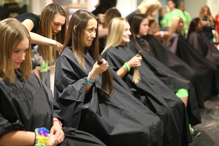 Dancers hold their hair that has been cut off to donate during the 10th hour of the 22nd Dance Marathon in the Iowa Memorial Union on Saturday, Feb. 6, 2016. The minimum amount to donate was 8 inches. (The Daily Iowan/Valerie Burke)