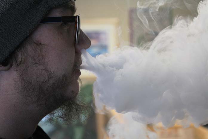 A+customer+at+Black+%26amp%3B+Gold+Vapors+blows+smoke+after+using+his+e-cigarette.+Coralville+is+looking+into+banning+e-cigarettes+in+places+that+smoking+is+banned.+%28The+Daily+Iowan%2F+Alex+Kroeze%29