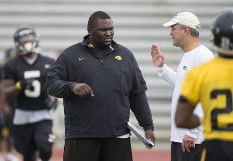 Iowa Hawkeyes head coach Kirk Ferentz  talks with graduate assistant Kelvin Bell during the teams 13th Outback Bowl Practice Saturday, Dec. 28, 2013 as they prepare to face the LSU Tigers in Tampa.  (Brian Ray/hawkeyesports.com)
