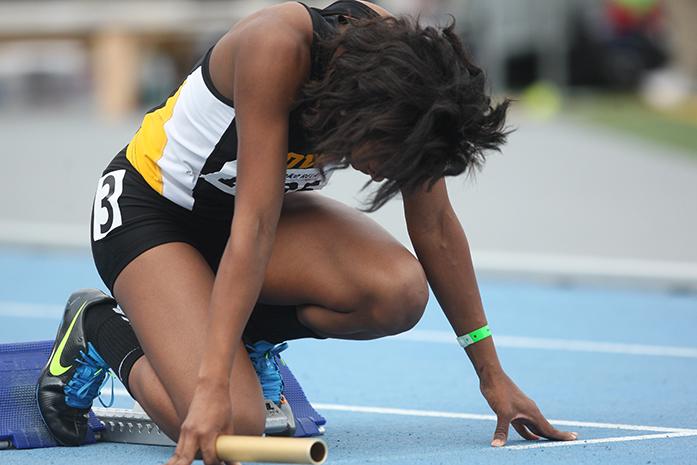 Iowa runner Elexis Guster stands in the ready position before the womens 4 x 400 meter relay at Drake Stadium on Saturday, April 26, 2014. Iowa placed seventh. (The Daily Iowan/Joshua Housing)
