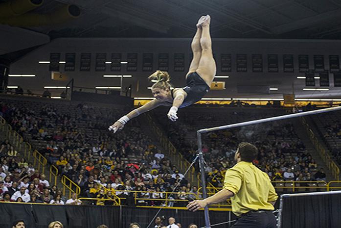 Iowa gymnast Mollie Drenth swings off the bar at Carver Hawkeye, on Saturday, Apr 2, 2016. Iowa took 4th place, scoring total of 195.450 for team score. (The Daily Iowan/Peter Kim)