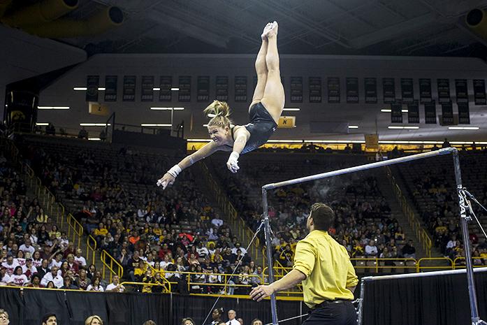Iowa gymnast Mollie Drenth swings off the bar at Carver Hawkeye, on Saturday, Apr 2, 2016. Iowa took 4th place, scoring total of 195.450 for team score. (The Daily Iowan/Peter Kim)