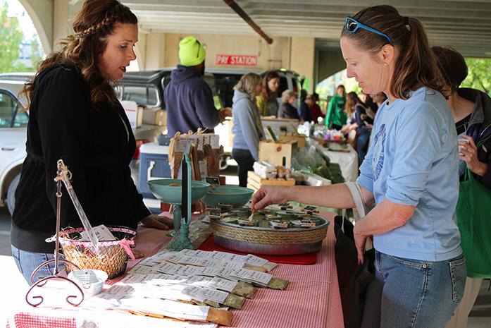 A customer samples some homemade dip at the Chauncey Swan Ramp on Wednesday, May 4, 2016. Iowas first farmers market of the year was held at the ramp. (The Daily Iowan/Tawny Schmit)