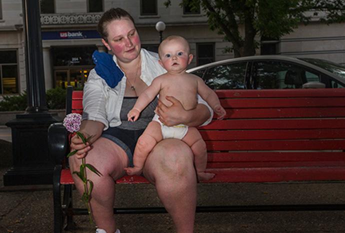 LeeAnn Yeckley and son Max sit on a bench outside the Pedestrian Mall during a vigil for the victims of the Orlando mass shooting on Monday. Iowa City is marking Pride Week, with a parade on Saturday. (The Daily Iowan/Jordan Gale)