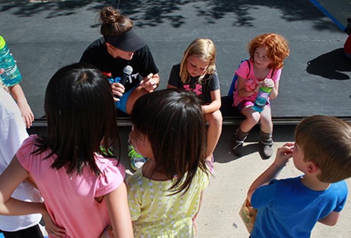 Kids gather around an event leader outside the Iowa’s Karro Hall of Fame as part of  Hy-Vee Family Fun Day on Sunday. (The Daily Iowan/Joseph Cress)