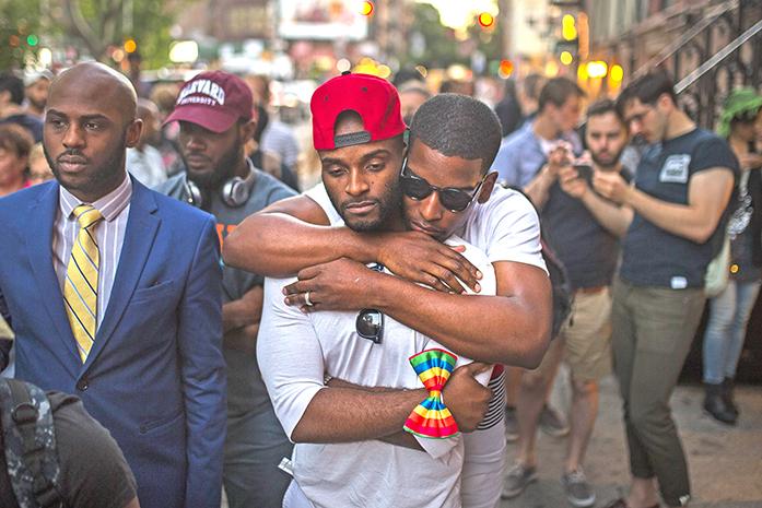 Couple hugs as people gather in front of a makeshift memorial to remember  the victims of a mass shooting in Orlando, Fla., in New York, Sunday, June 12, 2016.  A gunman wielding an assault-type rifle and a handgun opened fire inside a crowded gay nightclub early Sunday before dying in a gunfight with SWAT officers.  (AP Photo/Andres Kudacki)