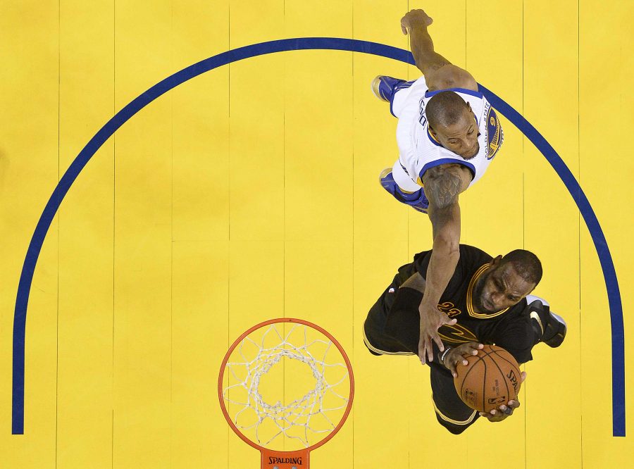 Cleveland Cavaliers forward LeBron James, bottom, shoots against Golden State Warriors forward Andre Iguodala during the second half of Game 7 of basketballs NBA Finals in Oakland, Calif., Sunday, June 19, 2016. The Cavaliers won 93-89. (John G. Mabanglo, European Pressphoto Agency via AP, Pool)