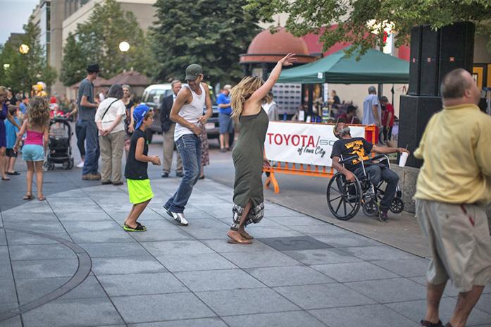 Concert goers dance to the music of The Surf Zombies in Iowa City's Ped Mall Friday night. The Surf Zombies are from Cedar Rapids and drew a large crowd Friday night for Friday Night Concert Series inside the Ped Mall. (The Daily Iowan/Sergio Flores)