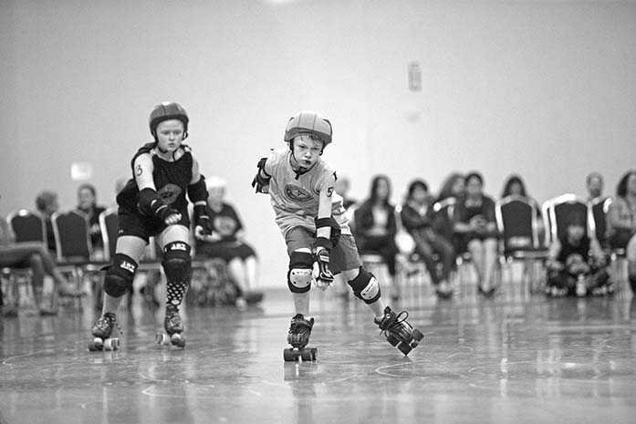 Midwest Mayhems no. 54, Bloodhound (right) passes Midwest Maulers no. 13, Loona at the Marriott Hotel in Coralville, Sunday, June 26, 2016. The I.C. Bruisers are Iowa Citys only roller derby league for children. (The Daily Iowan/Ting Xuan Tan)