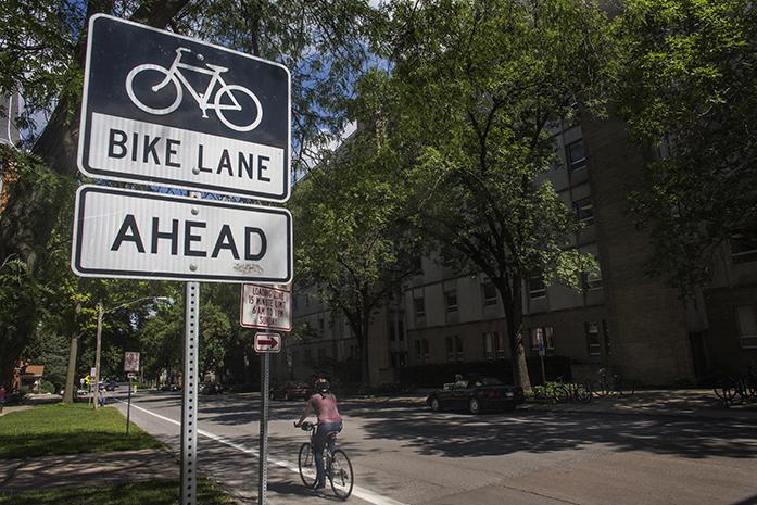 A bicyclist rides down East Jefferson Street in a bike lane on Tuesday, July 26, 2016.  Bike activist groups are pushing for more strict laws against reckless drivers in Iowa. (The Daily Iowan/Joseph Cress)