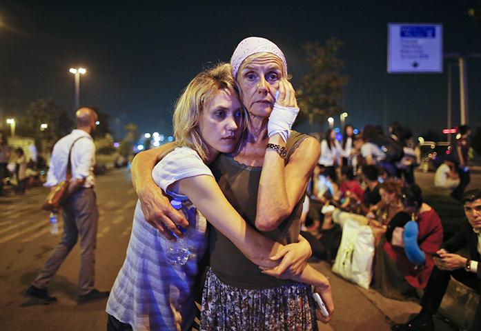 FILE -- In this Wednesday, June 29, 2016, file photo, passengers embrace each other following their evacuation after a blast, as they wait outside Istanbul's Ataturk airport, Turkey. As millions of Muslims around the world celebrate the end of Ramadan, many are struggling to come to grips with what has been a particularly bloody month of attacks that killed more than 350 people and spread terror across continents. (AP Photo/Emrah Gurel, File)