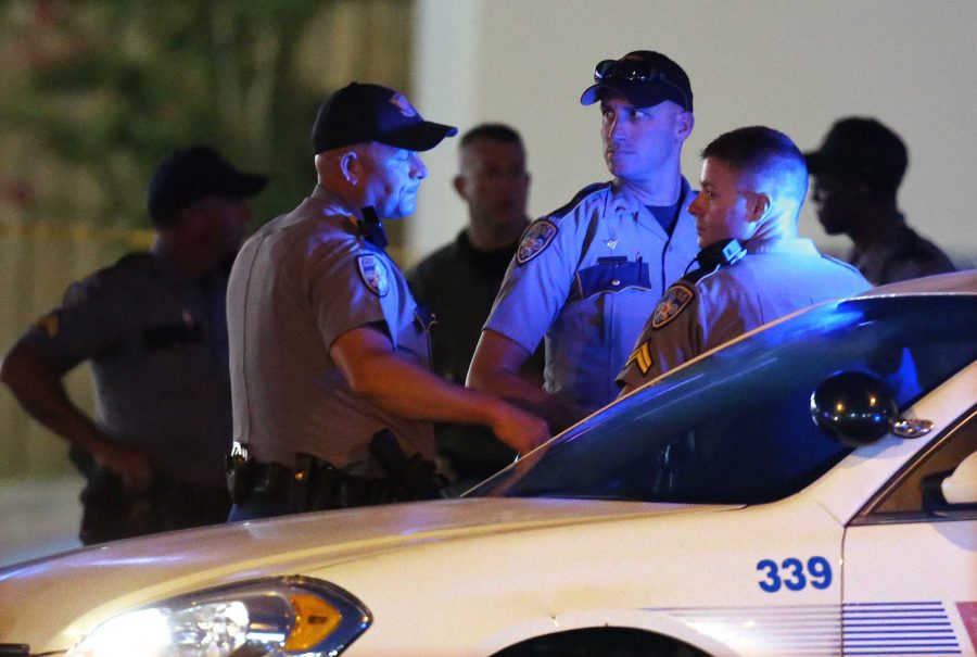 Law enforcement officials work the scene near where multiple Baton Rouge police officers were killed on Sunday, July 17, 2016, in Baton Rouge, La. (Curtis Compton/Atlanta-Journal Constitution via AP)