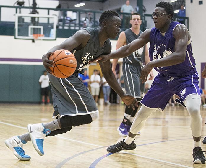 L.L. Pelling/Comfort Care Medicare's Peter Jok pushes forward toward the hoop around Beat the Bookstore/Culver's Wali Parks during a Prime Time League basketball game at the North Liberty Community Center on Thursday, July 7, 2016. (The Daily Iowan/Joseph Cress)