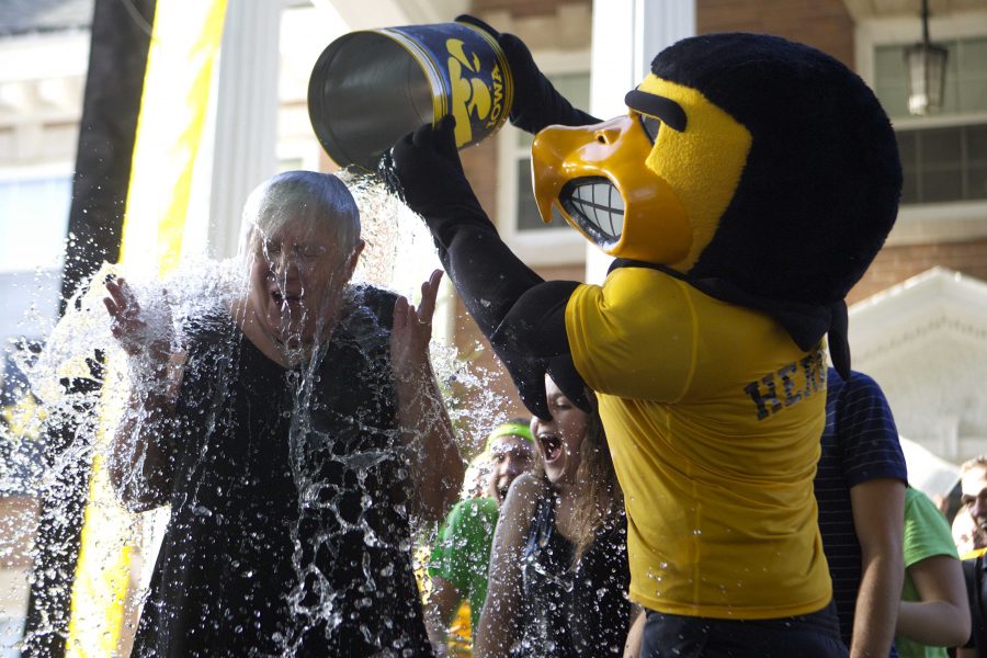 Former UI President Sally Mason gets ice water poured on her by Herky at President's Block Party on Sunday, Aug. 24, 2014. President Mason completed the ALS Ice Bucket Challenge along with other UI students. A recent study has reported the social-media trend helped fund advancements in research on ALS. (The Daily Iowan/file photo)