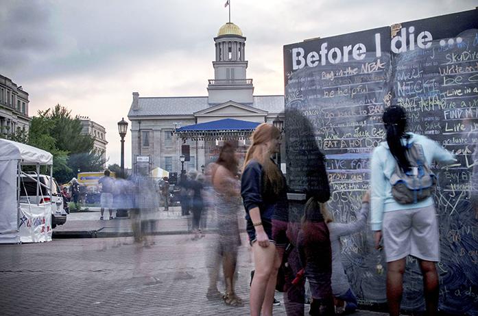 Community members engage in the "Before I Die" wall while at the iowa City Soulfest on Saturday August 29, 2015