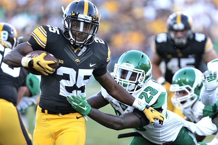 Iowa running back Akrum Wadley attempts to avoid a tackle by North Texas defensive back Kishawn McClain during the Iowa-North Texas game in Kinnick Stadium on Saturday, Sept. 26, 2015. The Hawkeyes defeated the Mean Green, 62-16. (The Daily Iowan/Valerie Burke)