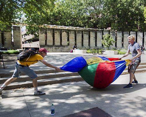 Zeta Beta Tau members Jared Bohlman and Nolan Lydolph deflate a beach ball along the T. Anne Cleary Walkway on Thursday September 1, 2016. The fraternity collected signatures from students as a fundraiser to support Childrens Miracle Network. (The Daily Iowan/Vivian Le)