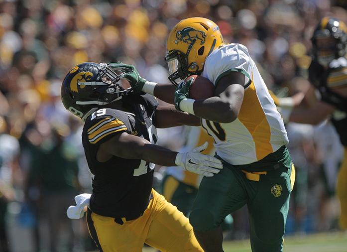 NDSU running back Lance Dunn stiff arms Iowa defensive back Miles Taylor during the Iowa-NDSU game at Kinnick on Saturday, Sept. 17, 2016. NDSU defeated Iowa in the final seconds of the game with a 37-yard field goal, 23-21. (The Daily Iowan/Margaret Kispert)