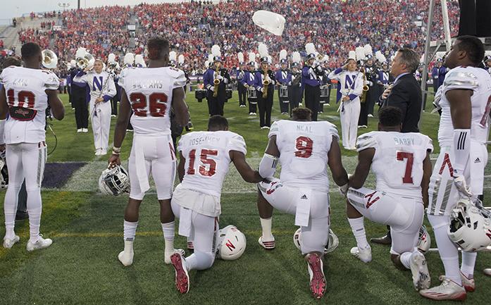 Nebraska linebacker Michael Rose-Ivey (15), defensive end DaiShon Neal (9) and linebacker Mohamed Barry (7) kneel during the national anthem before the team's NCAA college football game against Northwestern in Evanston, Ill., on Saturday, Sept. 24, 2016. Rose-Ivey said Monday he and his family have received racially charged criticism on social media, and said the responses show why the protest is necessary. (Matt Ryerson/Journal Star via AP)
