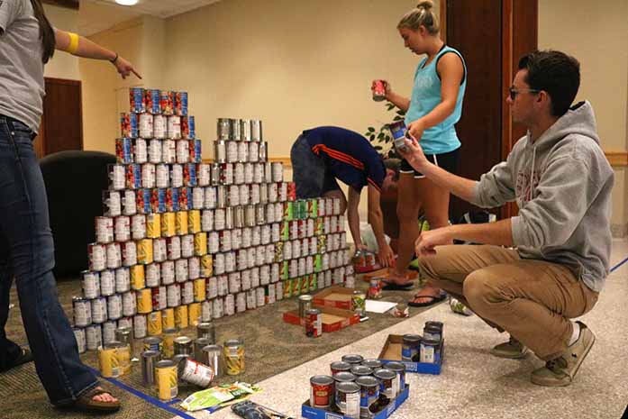 UI freshman Reece Smith teams up with other fraternity and sorority members to compete against other teams in a week long can structure building contest for the IMU food pantry on Monday September 26, 2016 in Hubbard Commons. Each can structure either represents some aspect of the University and University life or their own theme. (The Daily Iowan/Simone Banks-Mackey)